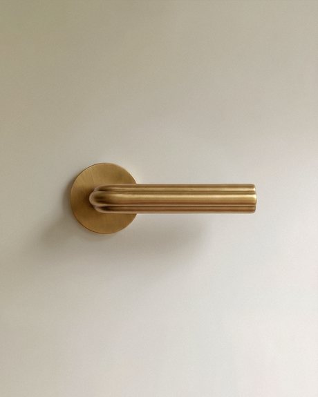 Gatsby Door Handle in Satin Brass, on a plain background
