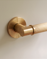 Vestige Door Handle in Satin Brass, on a plain background