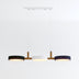 Three-light pendant fixture with wood arms and black, white, and navy fabric shades on white background.