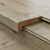 Close-up of a light-colored wood plank with a seamless edge detail and smooth, textured surface.