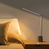 "Modern table lamp with aluminum and polycarbonate material placed on bedside table, offering focused illumination."