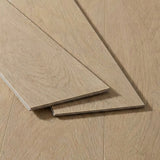 Three planks of light oak wood flooring with a sunwashed finish displayed on a matching installed floor.