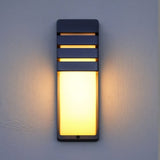 "Modern outdoor wall lamp with horizontal slats, durable aluminum, diffusing soft light in a cozy ambiance."