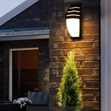 "Outdoor wall lamp on brick wall, made of aluminum, offering a welcoming light for outdoor spaces."
