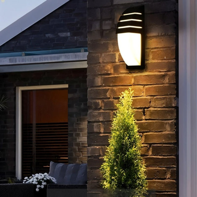 "Outdoor wall lamp on brick wall, made of aluminum, offering a welcoming light for outdoor spaces."