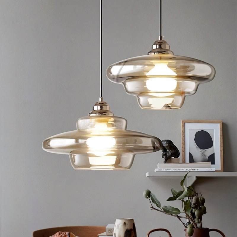 "Single Thuli pendant light featuring a transparent glass shade and sleek metallic finish for elegant lighting."