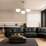 "Pendant lamp with three glass shades and a golden finish, illuminating a chic living room."