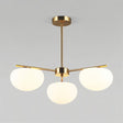 "Golden pendant lamp with three glass shades, adding elegant lighting to a modern living room."