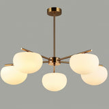 "Golden pendant lamp with five glass shades, creating ambient light in a stylish dining space."