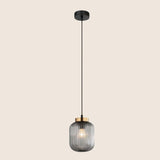 "Pendant light with black glass shade and gold accent, hanging with a sleek black cord in a minimalist design."