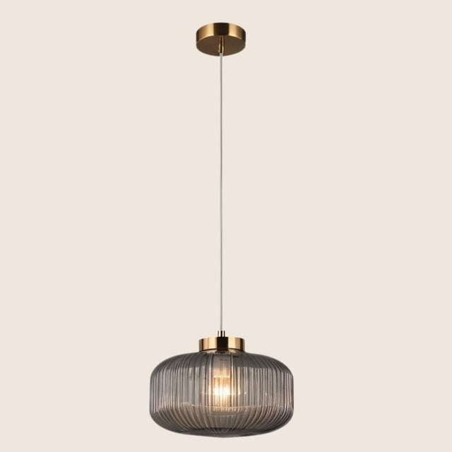 "Pendant light with Cylinderical Clear glass shade and elegant gold finish, providing a modern and sophisticated touch."