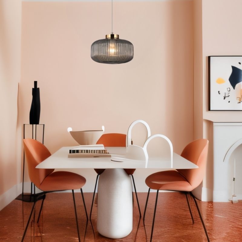 "Glass and iron pendant light with clean lines, adding elegance to a minimalist dining room with modern furniture."