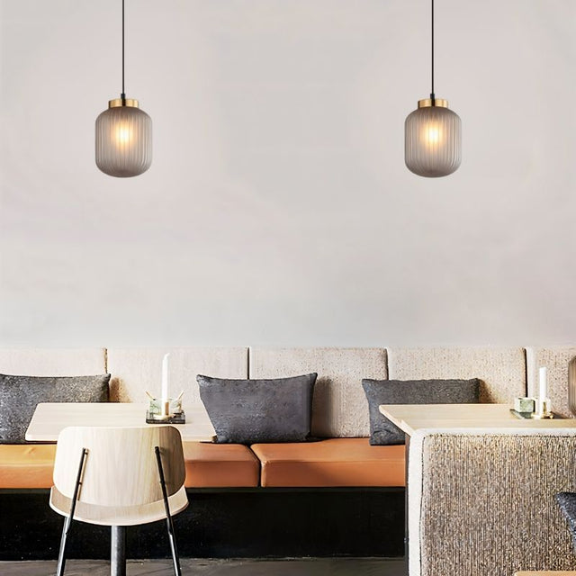 "Modern pendant light made of glass and iron, installed in a chic living room with minimalist décor, perfect for modern spaces."