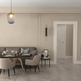 "Glass and iron pendant light, featuring a minimalist design, hanging over a dining table in a stylish, contemporary dining room."