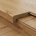 Close-up of a wooden floor edge with a sleek, rounded molding in a natural wood finish.