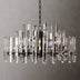 Prizma round chandelier with black metal frame and clear geometric glass prisms, hanging against a plain grey background.