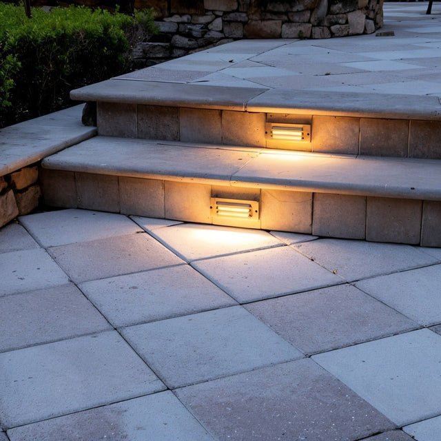 "Brass step light fixture installed on outdoor staircase, providing enhanced visibility and safety, made from weather-resistant brass with a horizontal grille design"
