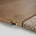 Oak reducer molding sloping between hardwood and lower flooring