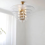 "A clear Murano glass chandelier with layered petals, viewed from below against a white ceiling and curtain."