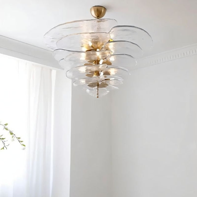 "A clear Murano glass chandelier with layered petals, viewed from below against a white ceiling and curtain."