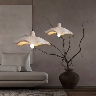 "wavy pendant lights in cozy room, organic cement shades, warm ambient lighting, minimalist interior decor"