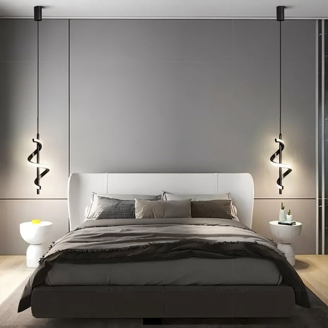 "Two black pendant lights with a spiral design, shown lit up on either side of a bed with gray bedding and a white headboard, in a room with gray walls and modern side tables."