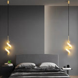 "Two gold pendant lights with a spiral design, shown lit up on either side of a bed with gray bedding and a gray headboard, in a room with dark gray and light gray walls."