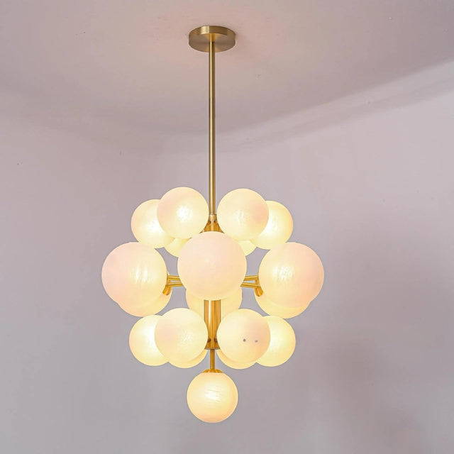 "A modern brass chandelier with frosted glass globes, showcasing its unique arrangement and soft, ambient light."