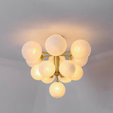 "A modern brass chandelier with frosted glass globes mounted on a ceiling, emitting a soft, ambient light."