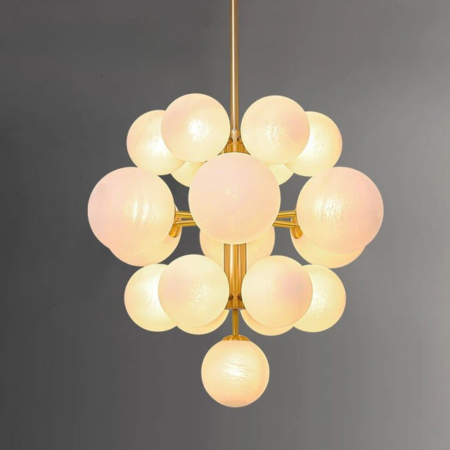 "A modern brass flush mount chandelier with frosted glass globes, providing a soft, ambient light."