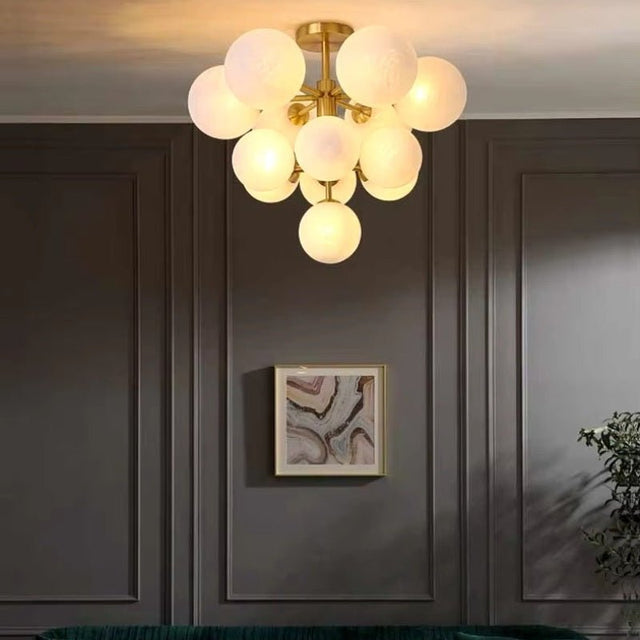 "A modern brass chandelier with frosted glass globes illuminating a contemporary living room with a minimalist aesthetic."