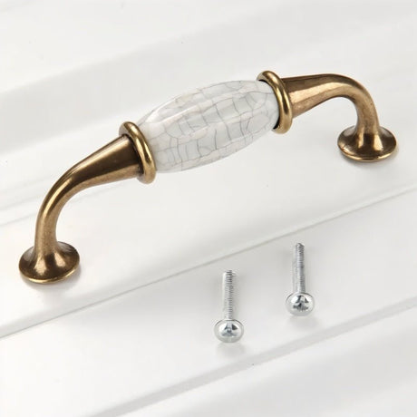 "Close-up of a ceramic pull bar handle with a crackled glaze and antique brass supports, showcasing its vintage charm and sturdy construction."