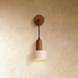 Wooden pendant light with natural finish dome shade and black metal hardware, mounted above bedside table in modern bedroom.