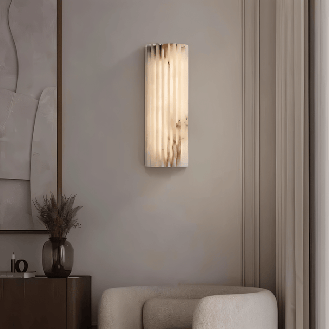"Modern cloud stone wall lamp with vertical grooves, providing a warm glow in a contemporary bedroom."