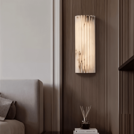 "Modern cloud stone wall lamp with a vertically grooved design, mounted on a wall in a contemporary home setting."