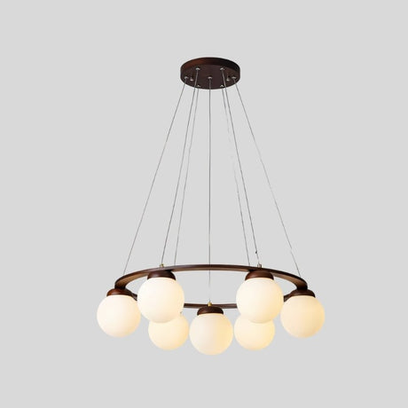 "Angled view of a circular dark wood frame chandelier with seven frosted glass globes, suspended by cables, isolated on a light gray background."
