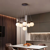 "Circular wood frame chandelier with frosted glass globes hanging above a dining table in a modern dining room."