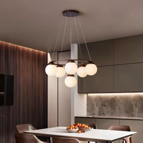 "Circular wood frame chandelier with frosted glass globes hanging above a dining table in a modern dining room."