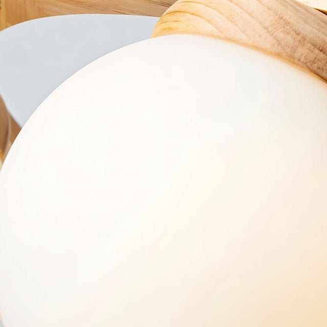 "Close-up of a frosted glass globe and wooden frame of the Alyn chandelier."