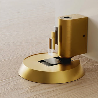 "Gold brass door stop installed on a light wood floor, showcasing its modern design."