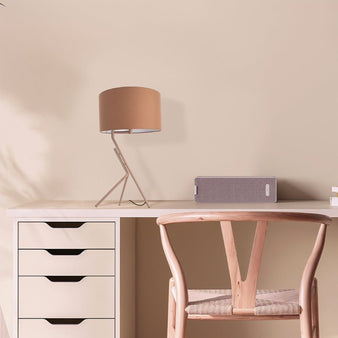 "Anubi table lamp with an apricot fabric shade and geometric base on a desk in a modern home office."