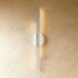 Modern chrome wall sconce with circular canopy and vertical linear arms, front view on white background.