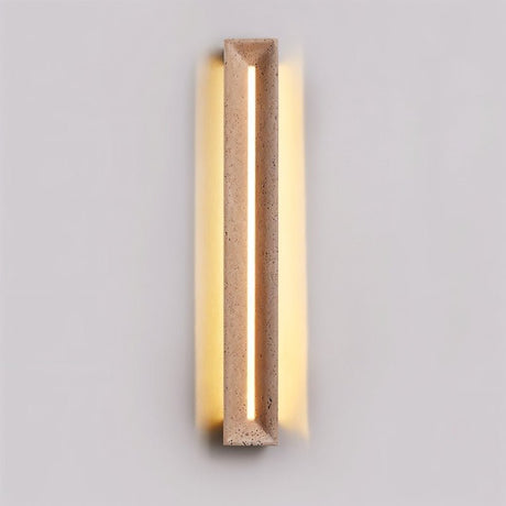 "Minimalist travertine wall lamp with a geometric frame, casting warm diffused lighting for a sophisticated ambiance."