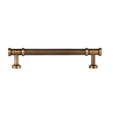"An elongated antique brass fluted pull bar with detailed end caps and a ribbed texture, isolated on a white background."