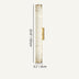Cylindrical alabaster wall sconce with brass hardware on a neutral background.