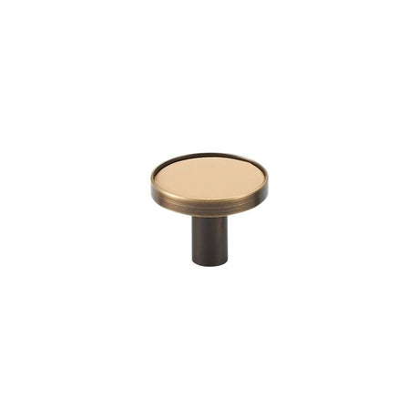 "A modern cream leather and brass cabinet knob on a white background."