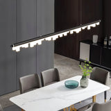 "Modern pendant light with a sleek aluminum frame and geometric acrylic diffusers illuminating a contemporary dining room."