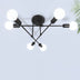 Black multi-arm ceiling light with six white globe shades mounted on white ceiling.