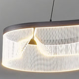 "Close-up of a modern chandelier featuring an undulating acrylic shade and sleek iron frame, showcasing its unique design."
