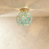 Golden teardrop cluster ceiling light fixture with warm amber glass on white ceiling in modern hallway.